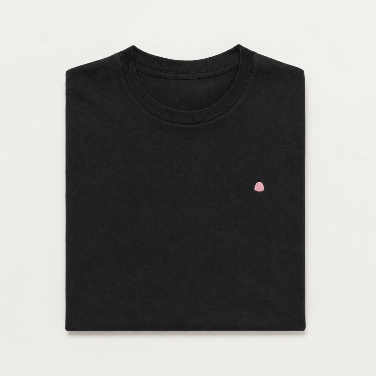 Folded black WireGum t-shirt with a small pink embroidered mark