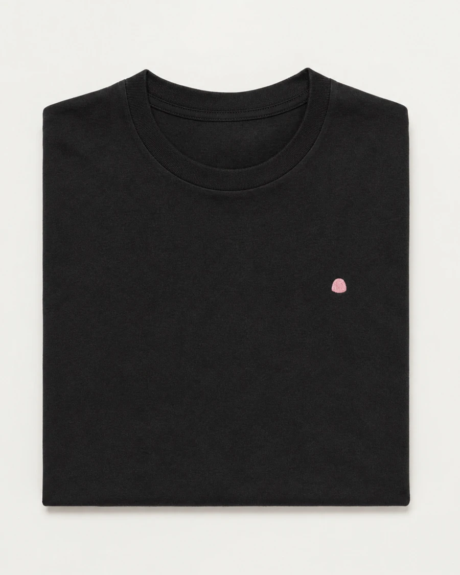 Folded black WireGum t-shirt with a small pink embroidered mark